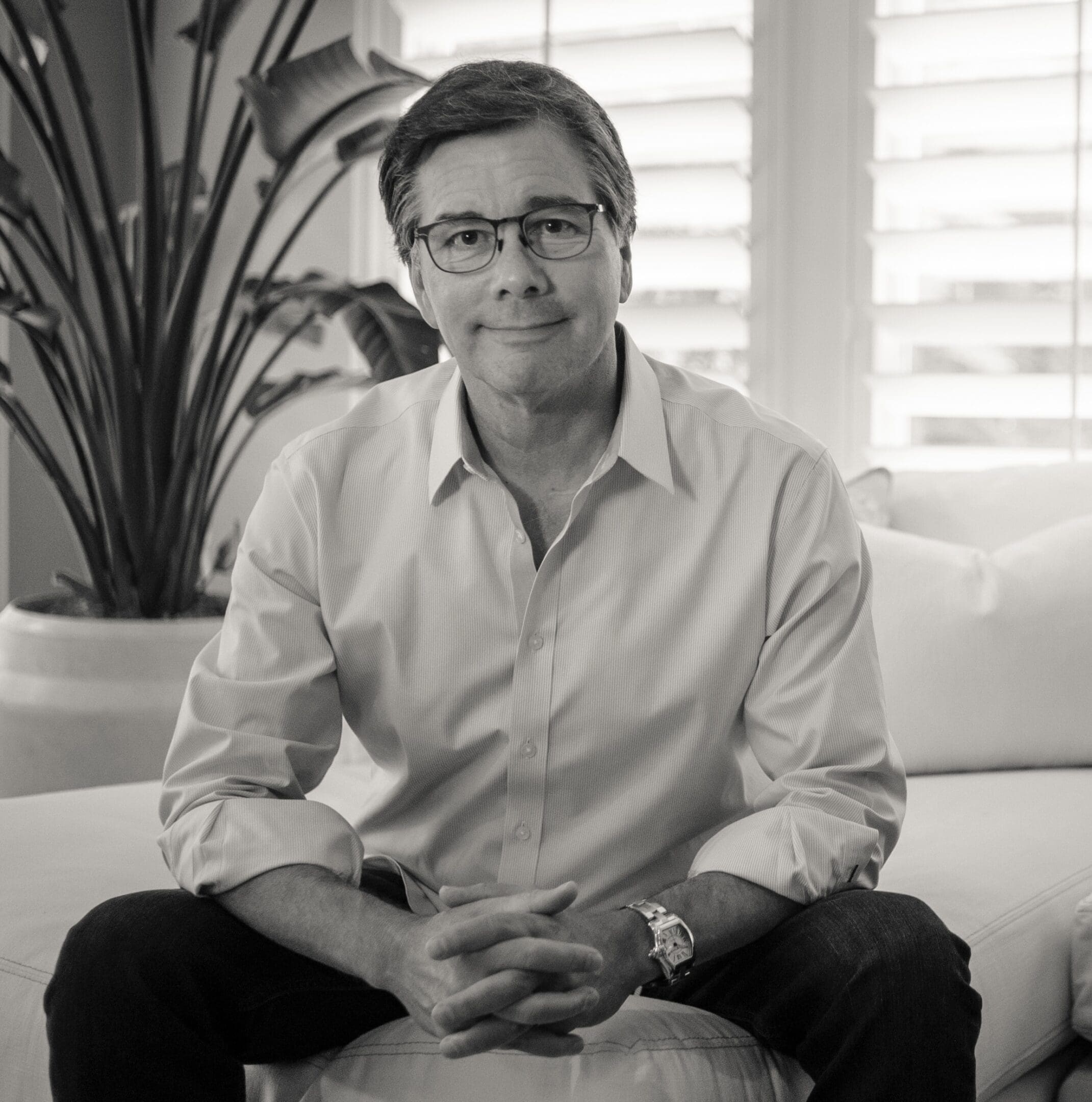 A man sitting on top of a white couch.